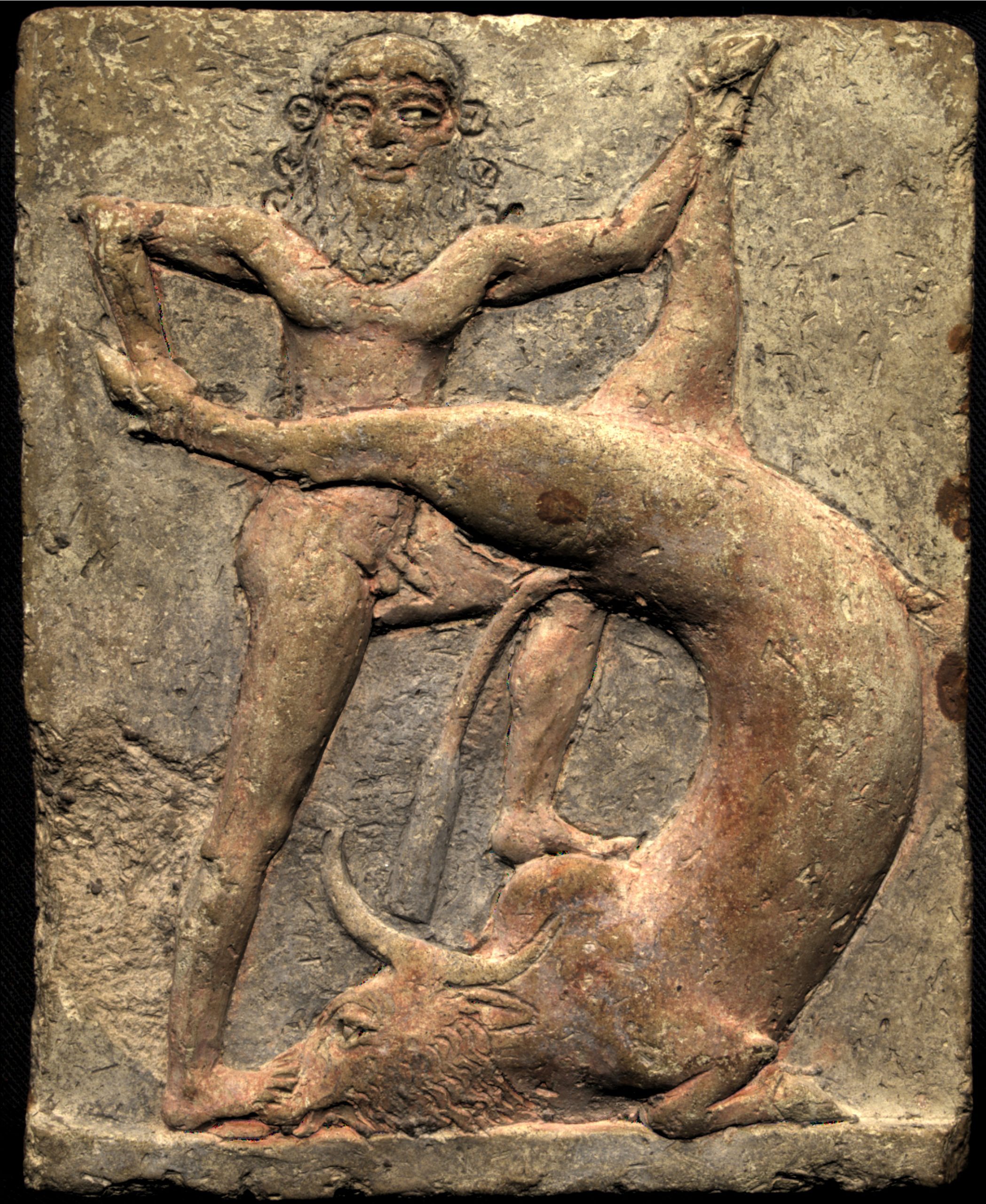 A relief depicting a Mesopotamian deity with bull horns symbolizing power and divinity