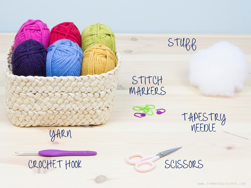 A collection of essential crochet tools and materials for amigurumi including yarn hooks stitch markers and safety eyes