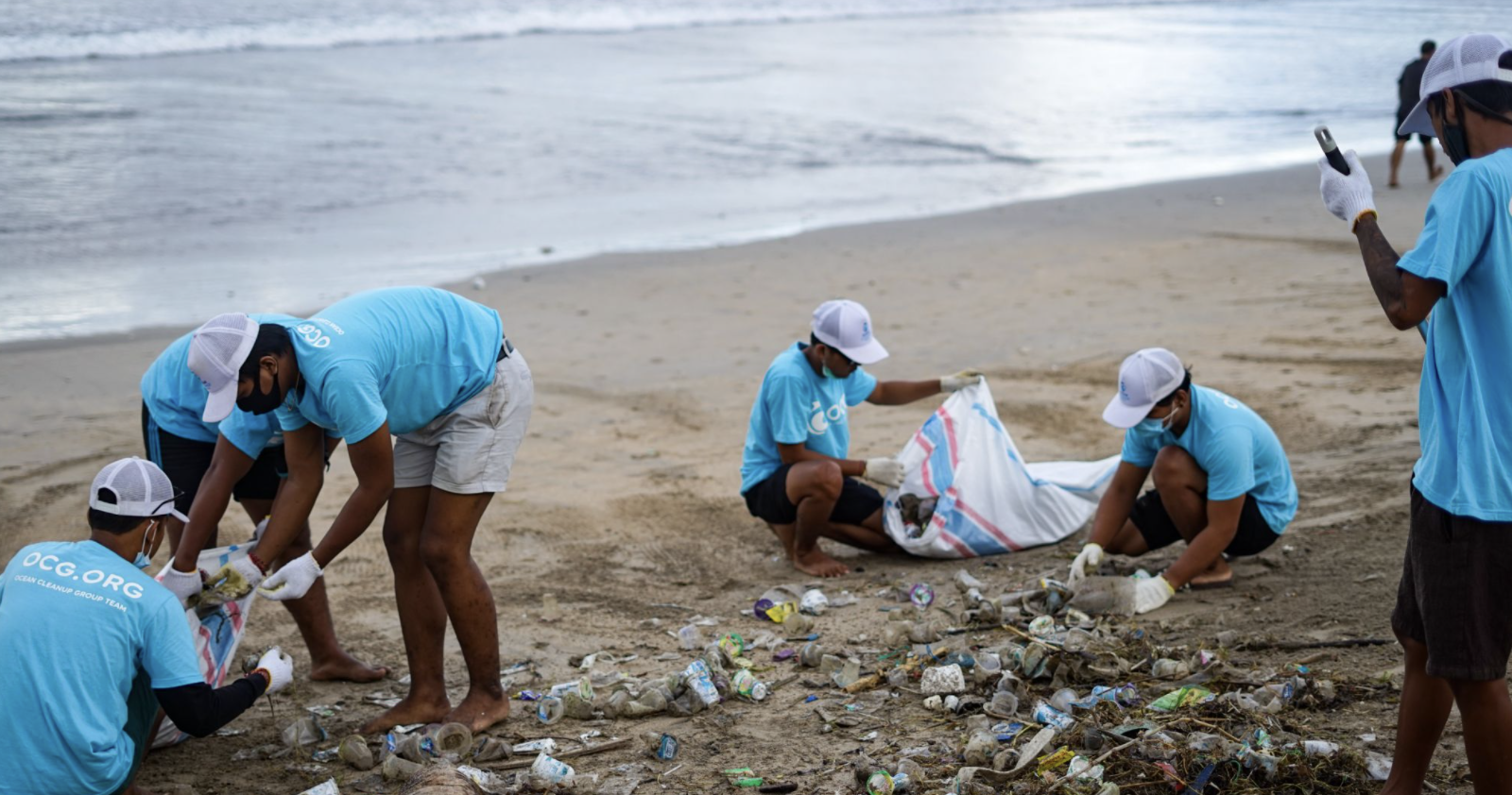 Volunteers are removing plastic pollution from a beach during a community cleanup event